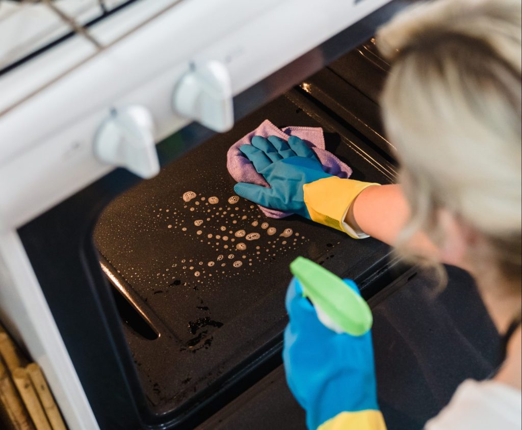 person cleaning oven
